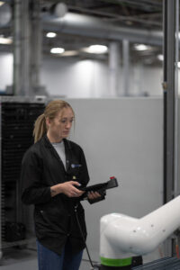 Manufacturing employee working alongside a cobot on a production floor at Intervala