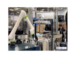 Collaborative robot working alongside a skilled manufacturing technician on an electronics assembly line